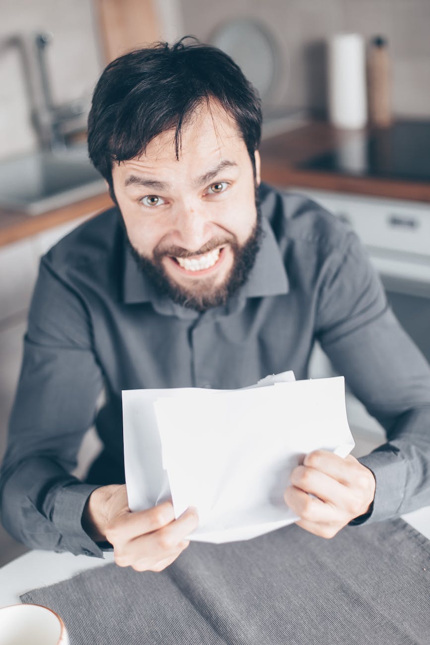 man in black long sleeve shirt holding white paper